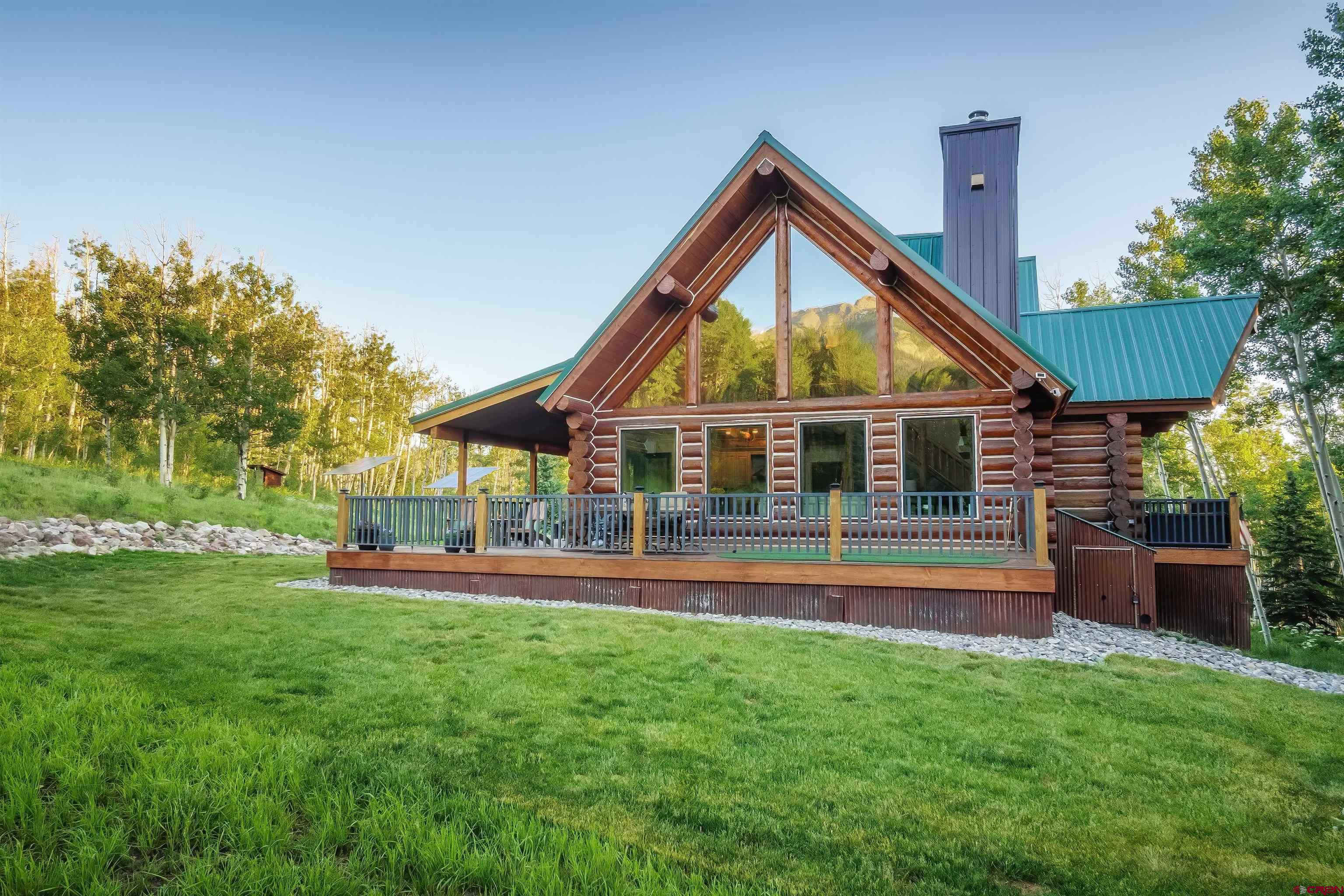 OFF-GRID COLORADO MOUNTAIN LIVING | 12.92 ACRES If you're looking for a true Colorado mountain property where privacy, hunting and recreation start right outside your door, this is it. Located at 9,423 feet in San Juan Vista, just 17 miles north of Ridgway and 33 miles from Telluride, this 12.92-acre property offers incredible views of S9, Hastings Peak and North Pole Peak, surrounded by aspen, ponderosa pine and scrub oak. Built in 2019, the 2,565 sq. ft. log home combines the character of a mountain cabin with the comfort of a newer home. The three-level floor plan offers 4 bedrooms and 3 bathrooms, multiple living spaces, a wood-burning stove, office, and an oversized 2-car garage with room for vehicles, mountain toys and gear. A separate 300 sq. ft. guest cabin creates the perfect space for guests, a private office, studio or additional getaway. COMPLETELY OFF-GRID — WITHOUT GIVING UP COMFORT The solar system powers the home, supported by battery storage and a brand-new backup generator. A private well supplies a 1,200-gallon cistern, while a sixzone hot-water heating system keeps the home comfortable through the colder months. HUNT. RIDE. HIKE. EXPLORE. For the outdoor buyer, this property is hard to beat. Located in GMU 70, you'll have private hunting and recreational access through an HOA easement, with mule deer and elk country surrounding you. Hike, mountain bike and four-wheel directly from the property. San Juan Vista Road provides a scenic 2.5-mile loop, with access toward Last Dollar Road and miles of surrounding mountain country. And when winter arrives, this place becomes something entirely different. Winter access is seasonal by snowmobile, providing the privacy and experience that buyers looking for a true backcountry property appreciate. Snowmobile to the home, explore the surrounding roads, or ski the terrain right from the property. 12.92 acres • 3 BR • 3 BA • 2019 log home • Guest cabin • Oversized 2-car garage • Solar + battery system • New generator • Private well + cistern • Private hunting access • GMU 70 • Seasonal winter access This isn't a property for someone looking for a typical mountain house.