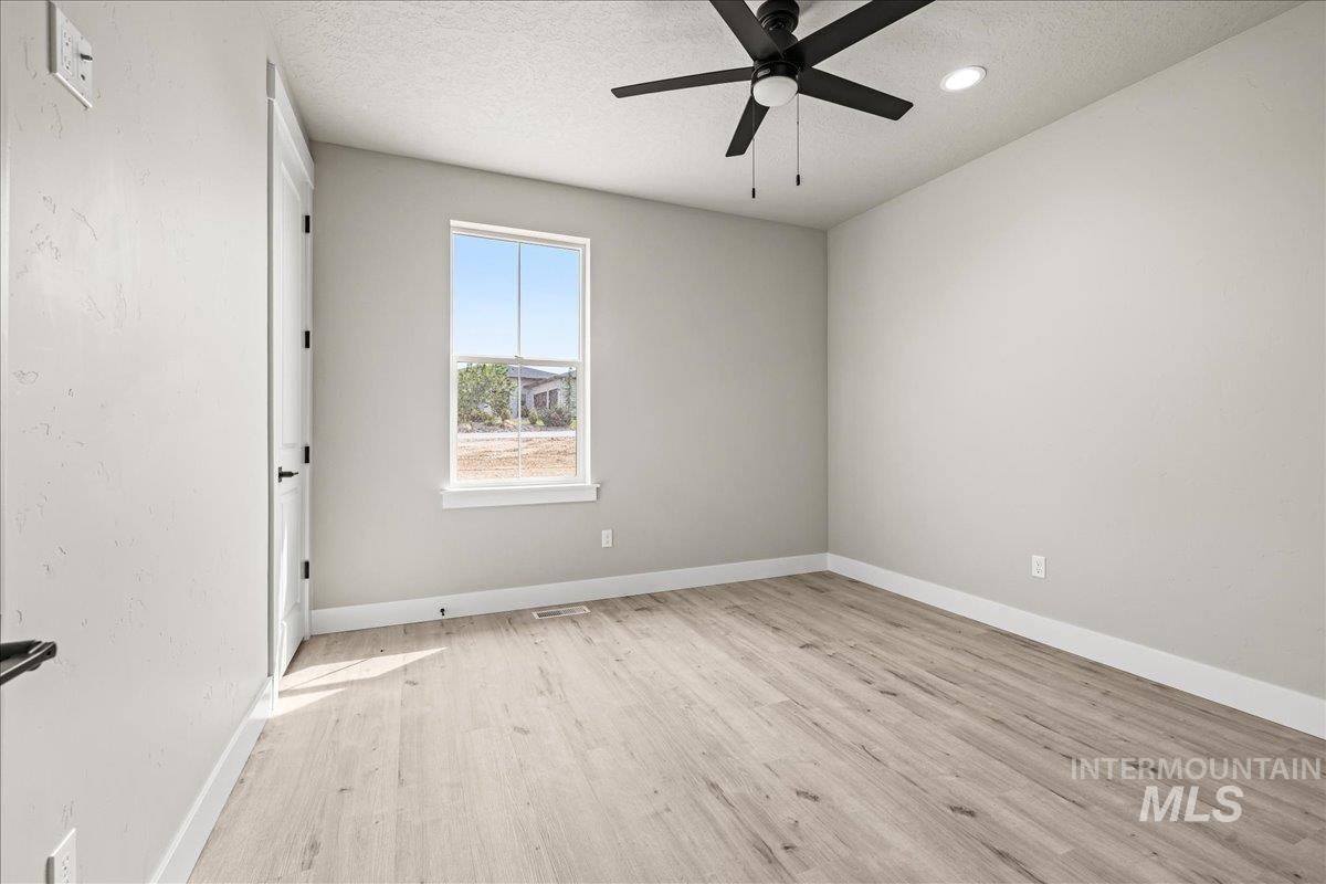 Unfurnished room featuring a textured ceiling, light wood-style floors, ceiling fan, and recessed lighting