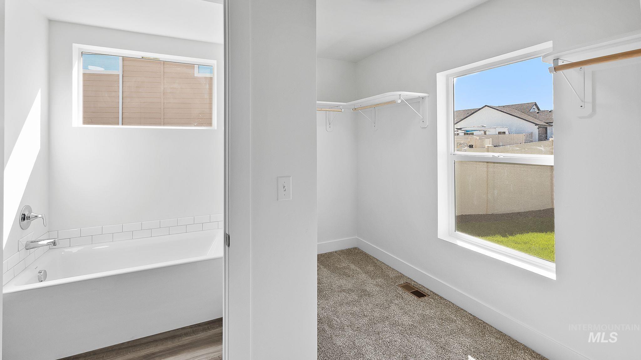 Full bath with a garden tub and a walk in closet