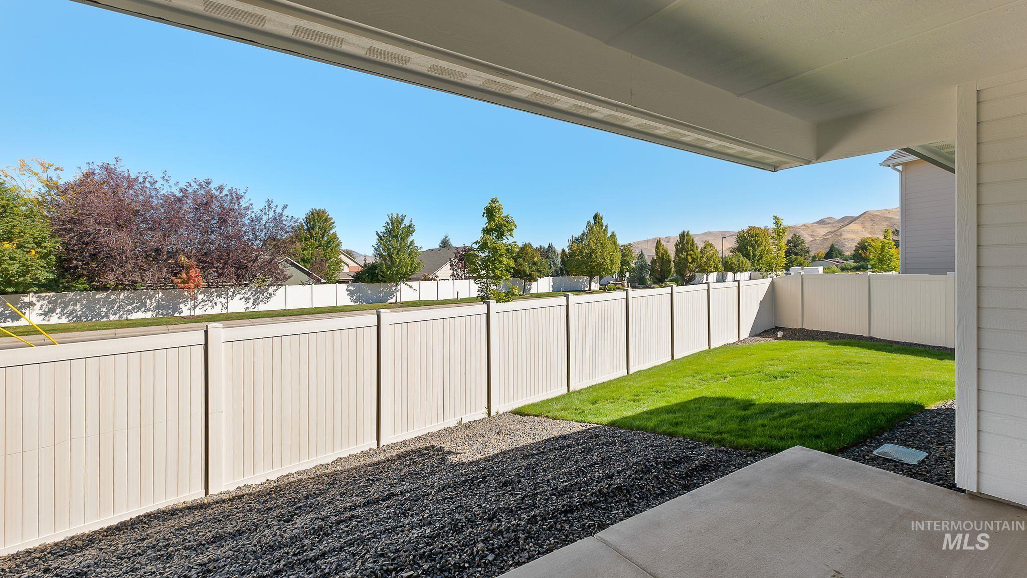Fenced backyard with a patio area and a residential view
