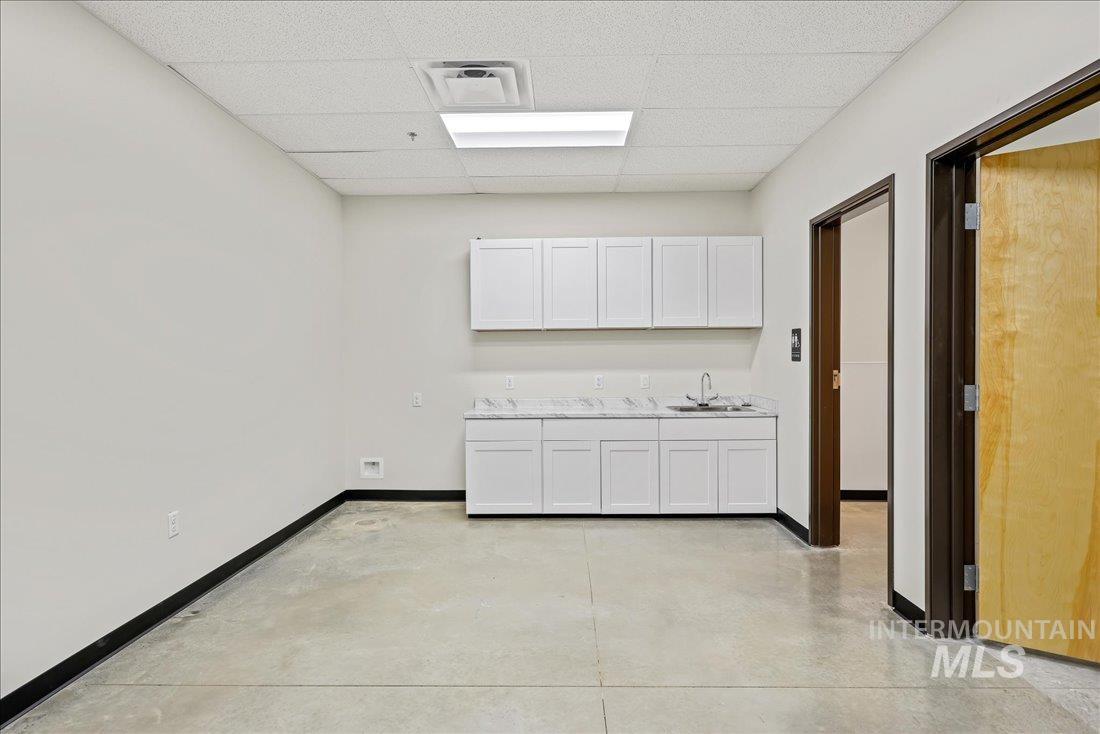 Washroom featuring concrete floors and a paneled ceiling