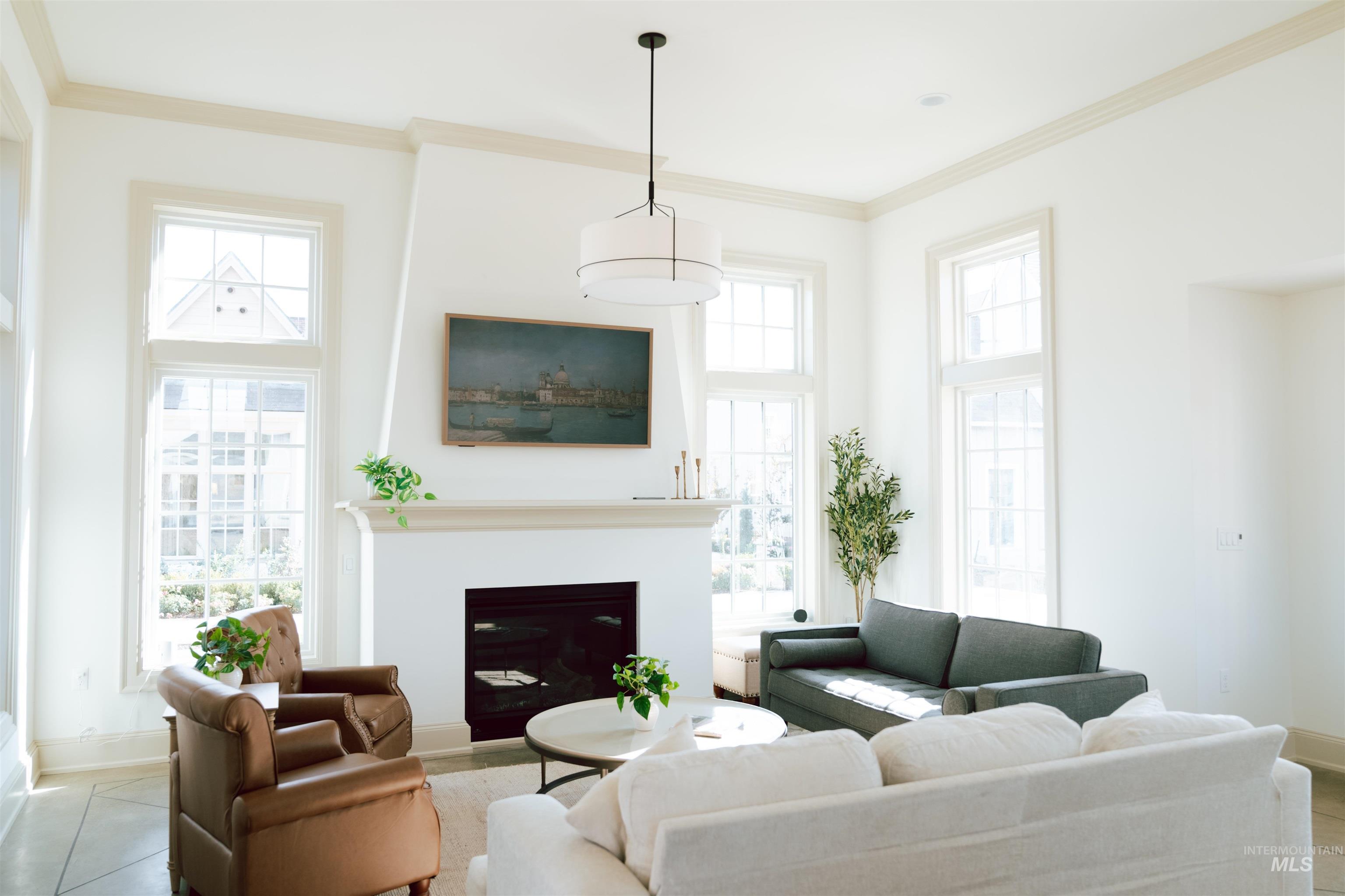 Living area featuring ornamental molding, a fireplace, plenty of natural light, and tile patterned flooring