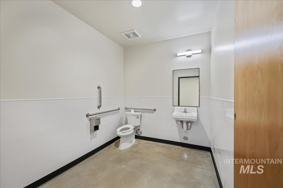 Half bathroom featuring baseboards and concrete flooring