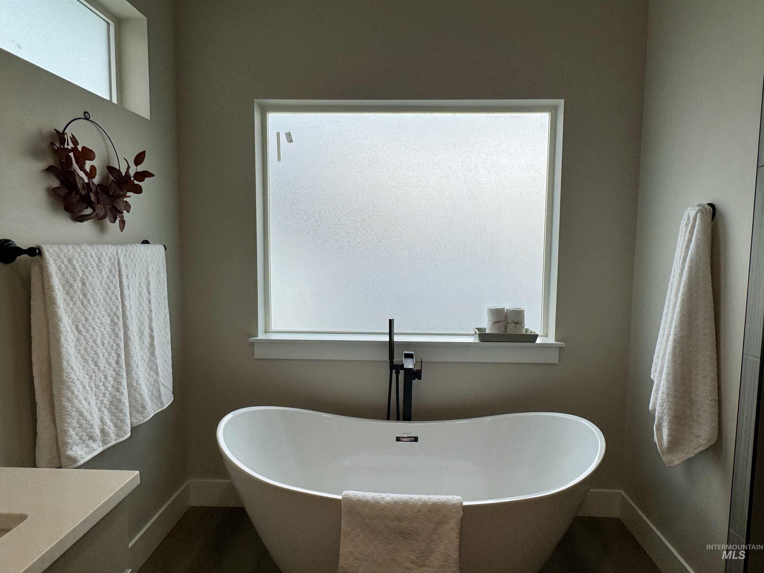 Full bathroom with a soaking tub and vanity