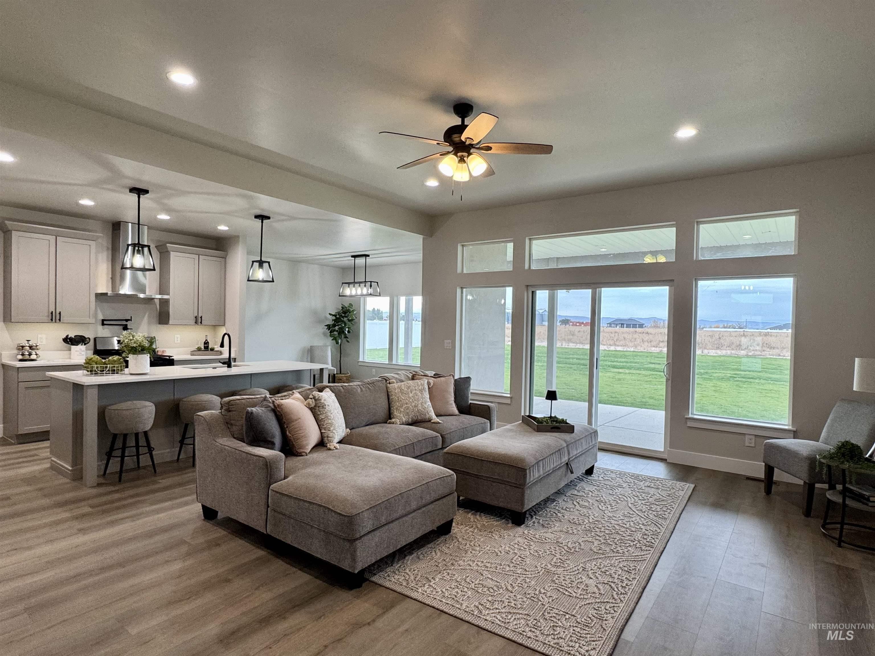 Living area with recessed lighting, light wood finished floors, and a ceiling fan