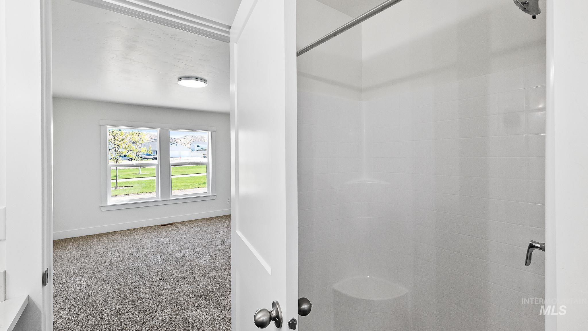 Bathroom with a stall shower and baseboards