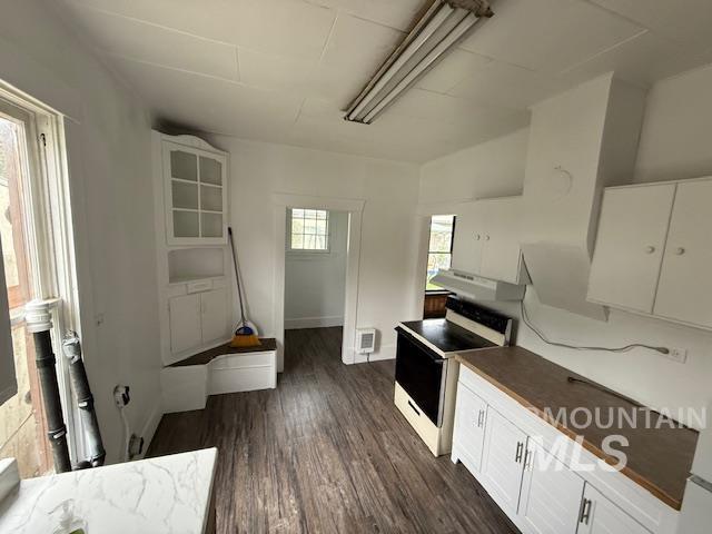 Kitchen featuring white cabinets, range with electric cooktop, and dark wood-style floors