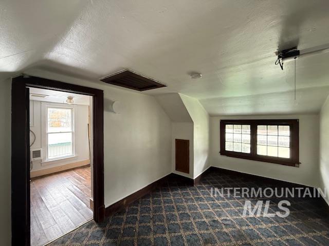 Bonus room with vaulted ceiling, a textured ceiling, and healthy amount of natural light