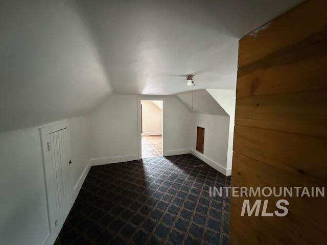 Bonus room featuring vaulted ceiling and baseboards