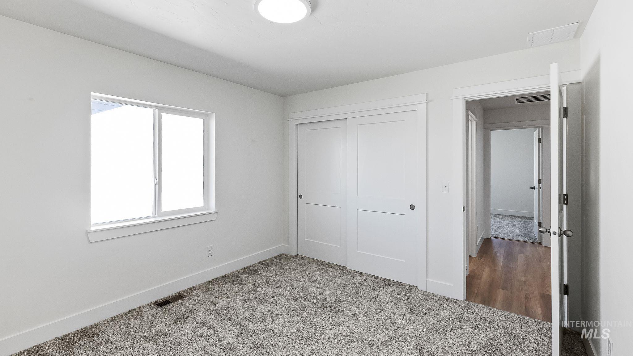 Unfurnished bedroom featuring carpet and a closet