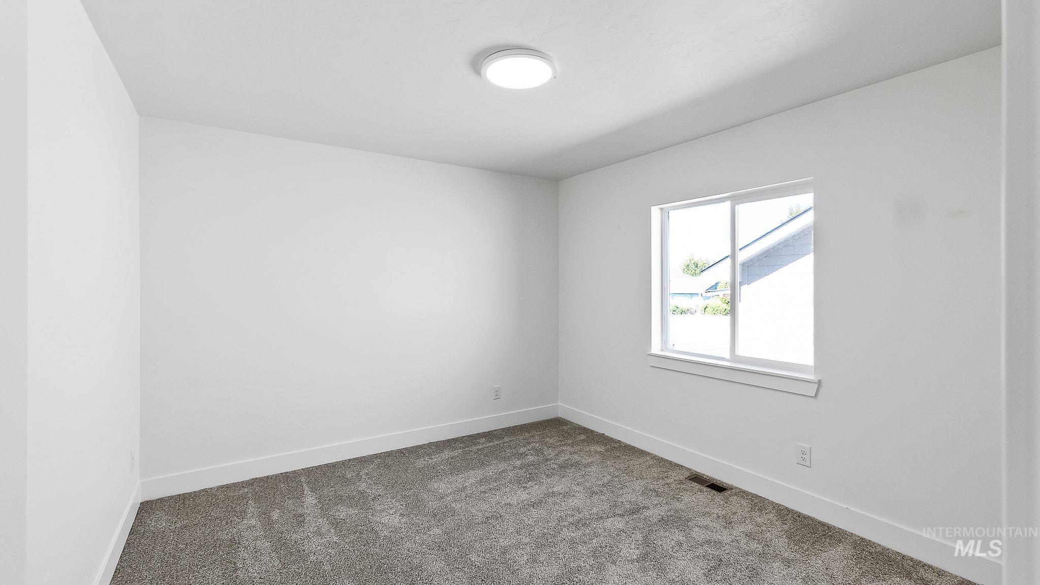 Empty room featuring carpet flooring and baseboards