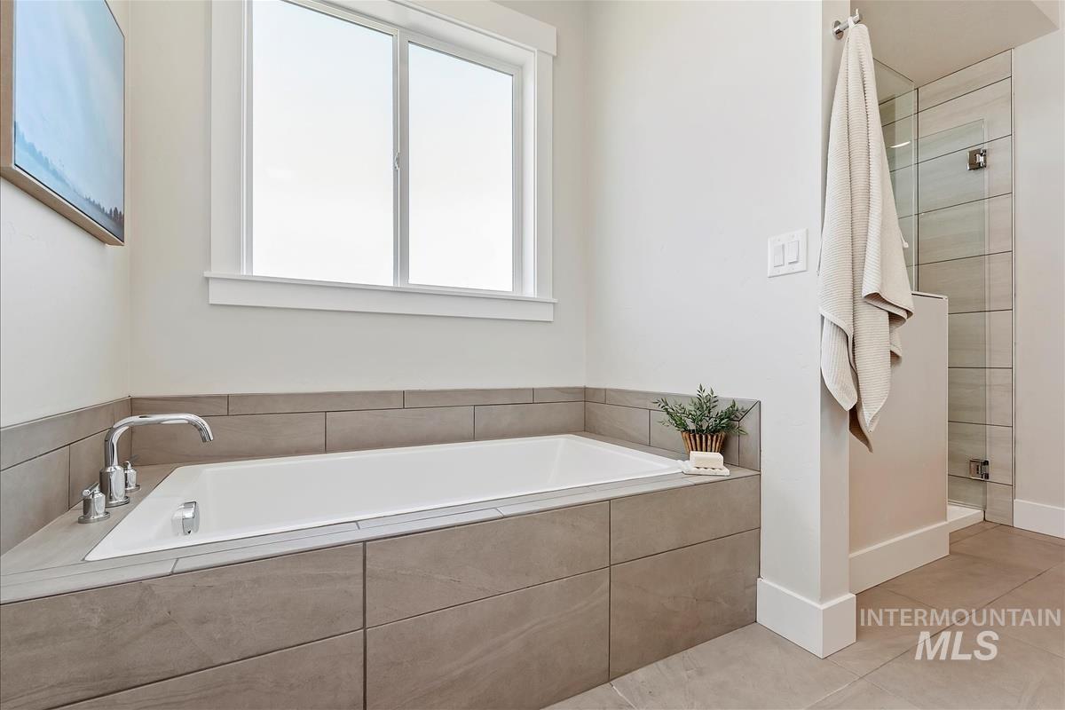 Full bath with a shower stall, a garden tub, and tile patterned floors