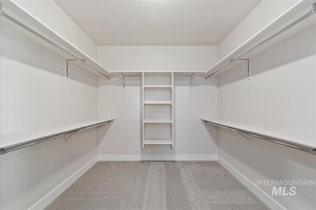 Walk in closet featuring light carpet