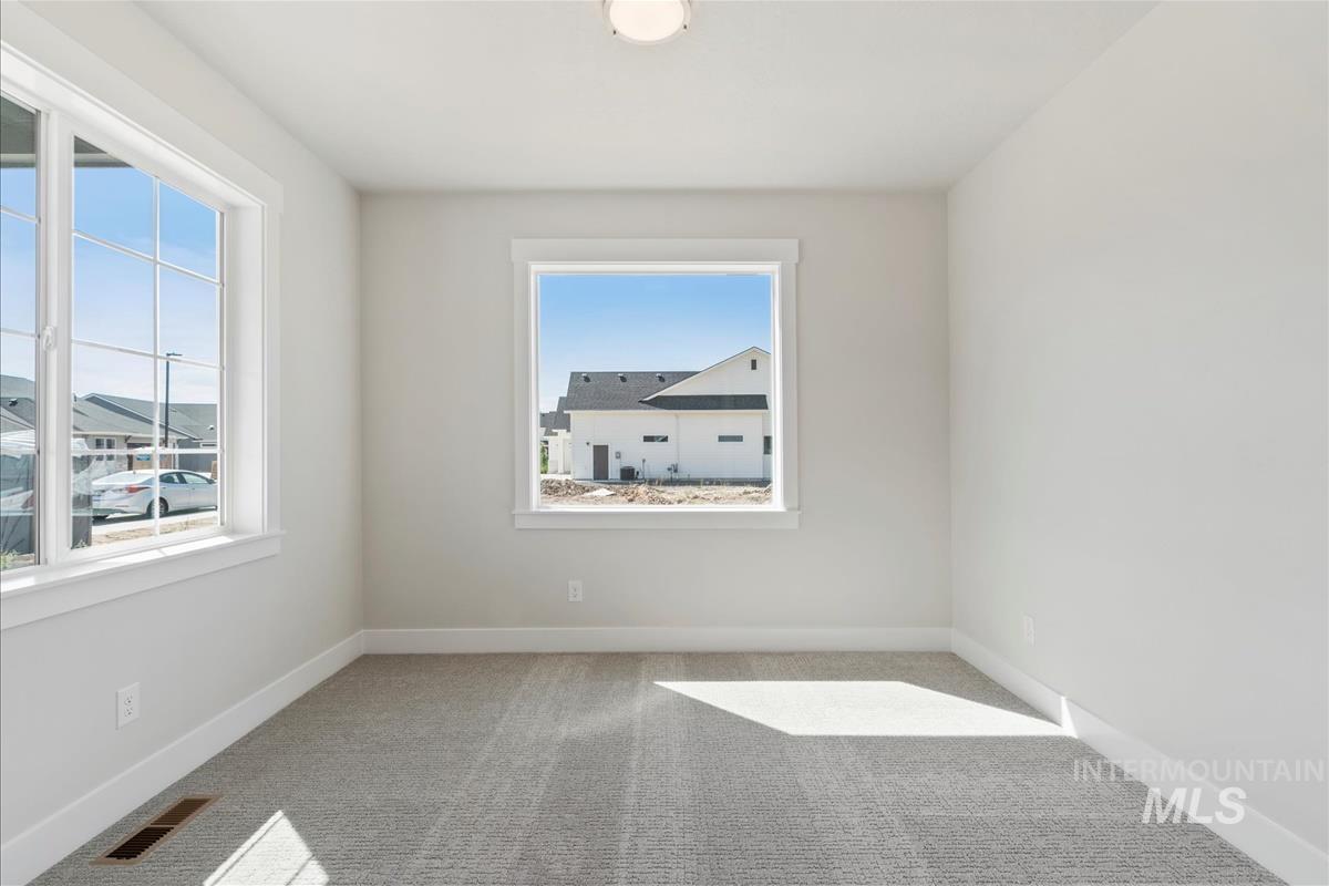 Carpeted empty room featuring baseboards