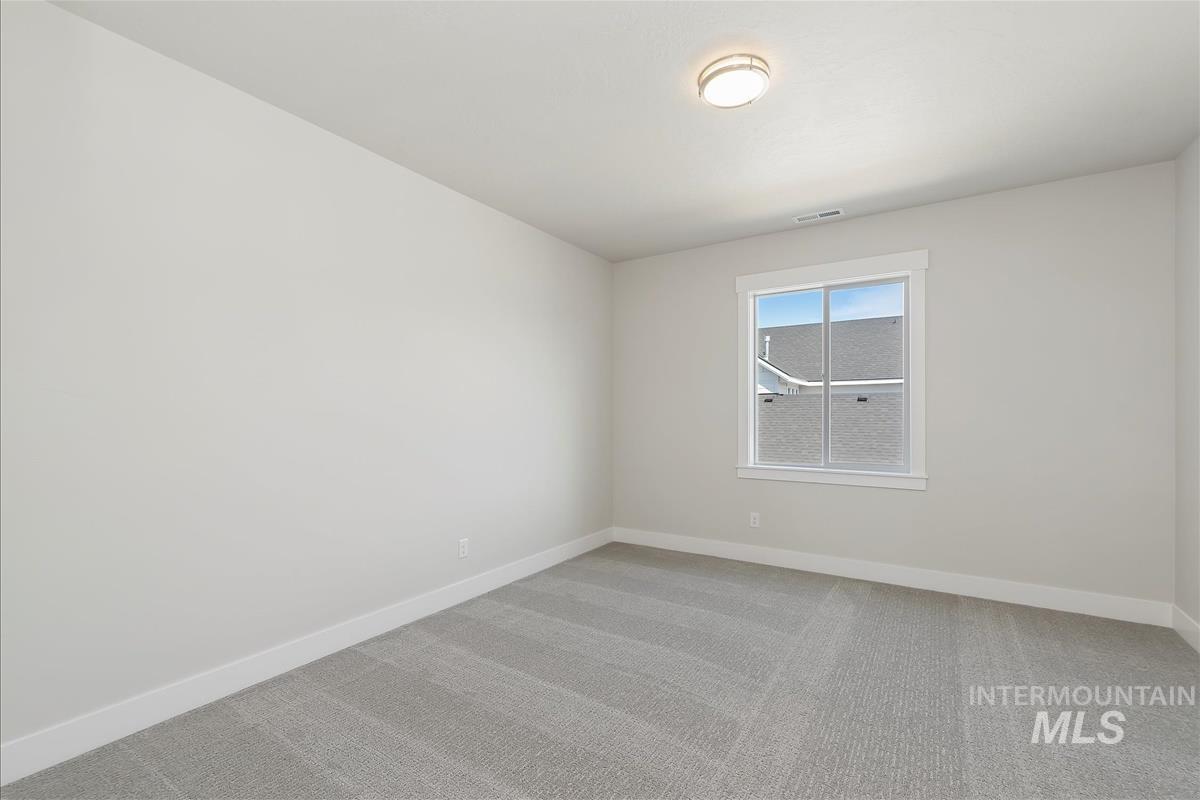 Unfurnished room with light colored carpet and baseboards