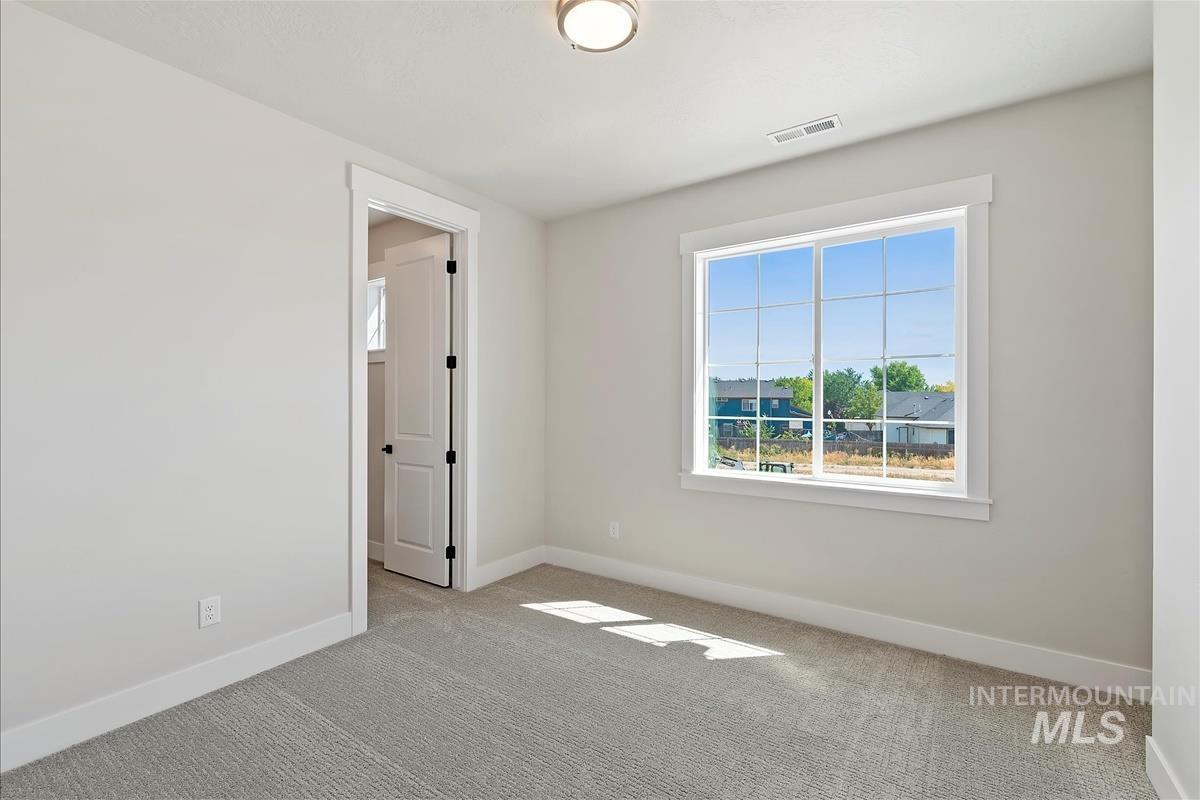 Carpeted spare room with plenty of natural light