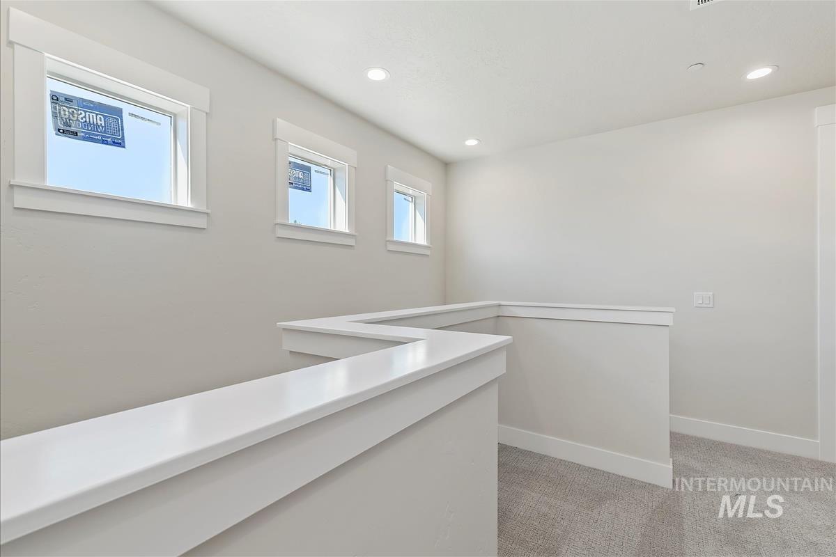 Hall featuring light colored carpet and recessed lighting