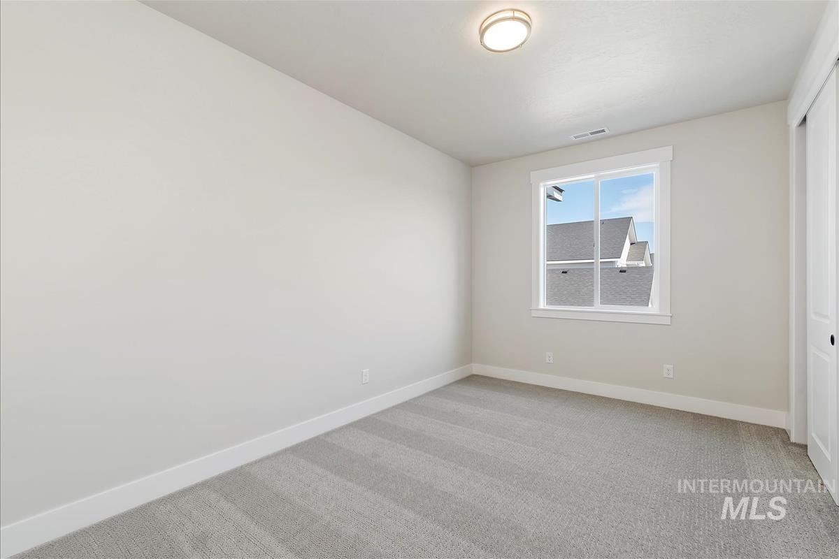 Unfurnished bedroom featuring light carpet and a closet