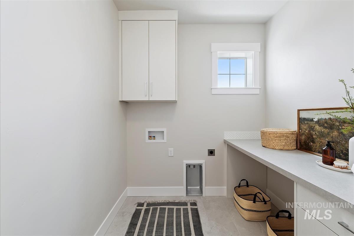 Laundry room with electric dryer hookup, cabinet space, and hookup for a washing machine