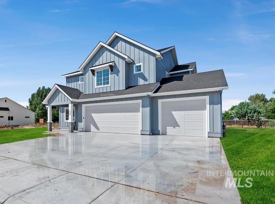 Modern farmhouse with board and batten siding, concrete driveway, a front yard, and a garage