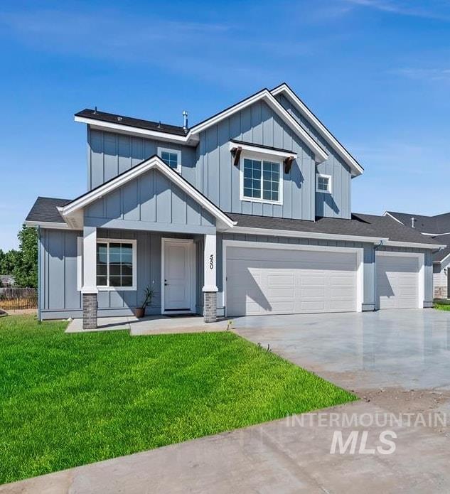 Modern inspired farmhouse featuring board and batten siding, concrete driveway, a front lawn, a garage, and covered porch
