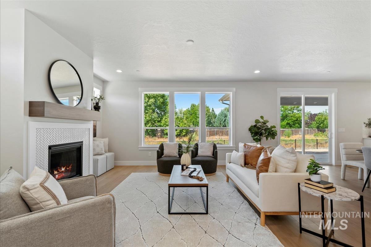 Living area featuring light wood-style flooring, a tile fireplace, recessed lighting, and a textured ceiling