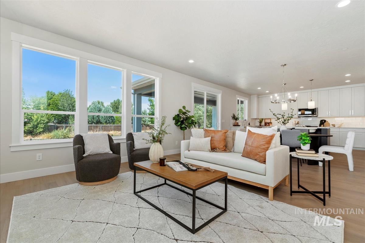 Living area with light wood-type flooring, a chandelier, and recessed lighting