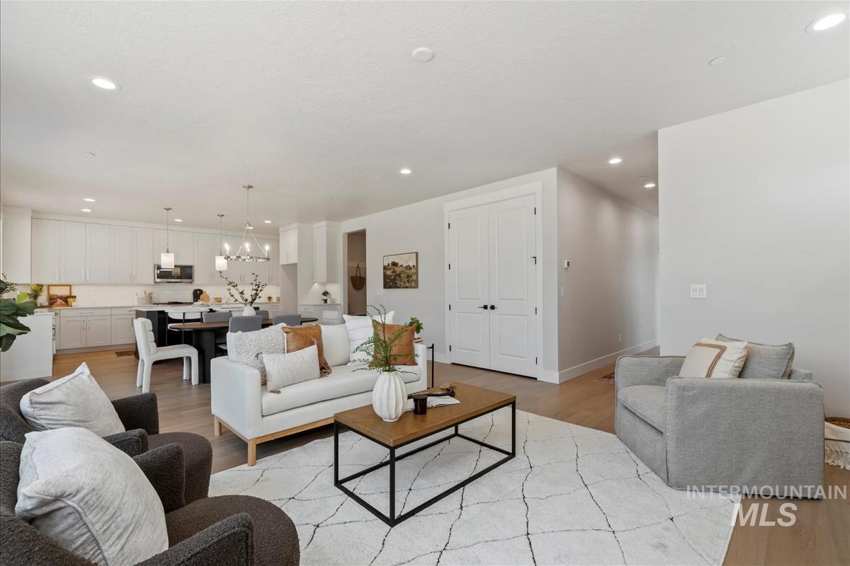 Living area featuring light wood-style flooring, recessed lighting, and a chandelier