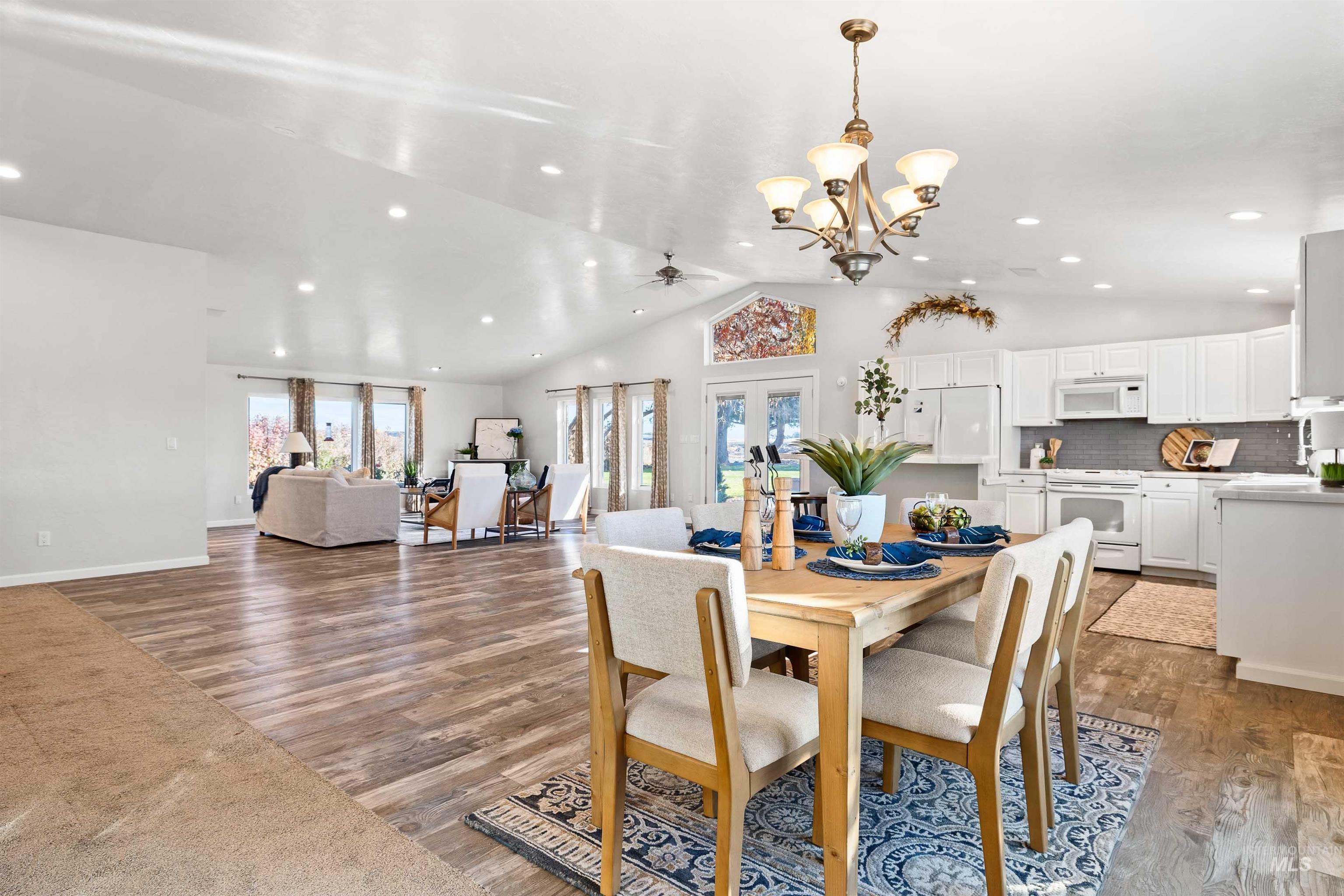 Dining area with lofted ceiling, ceiling fan, a chandelier, wood finished floors, and recessed lighting