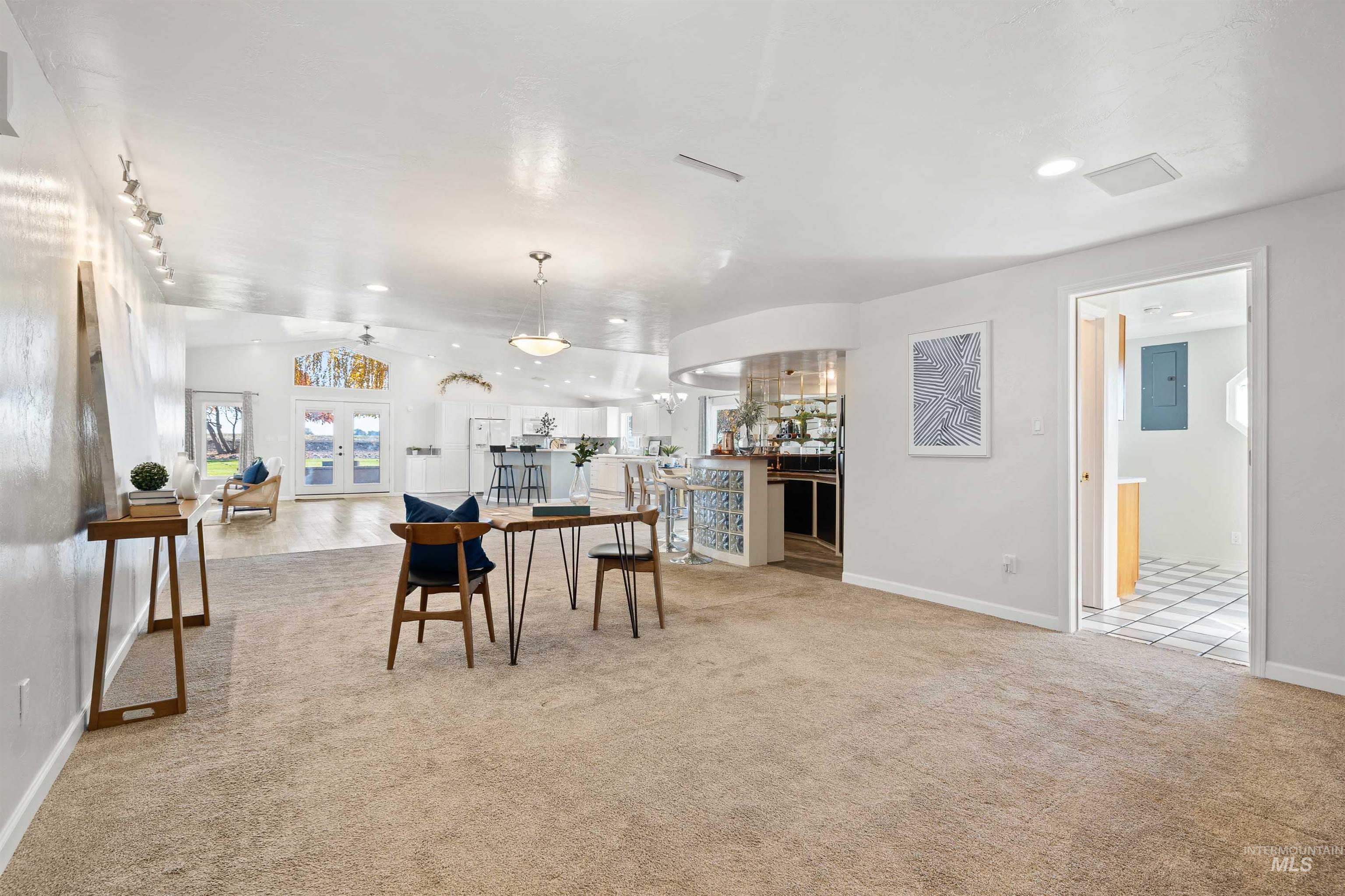 Dining room featuring light colored carpet, french doors, electric panel, and recessed lighting