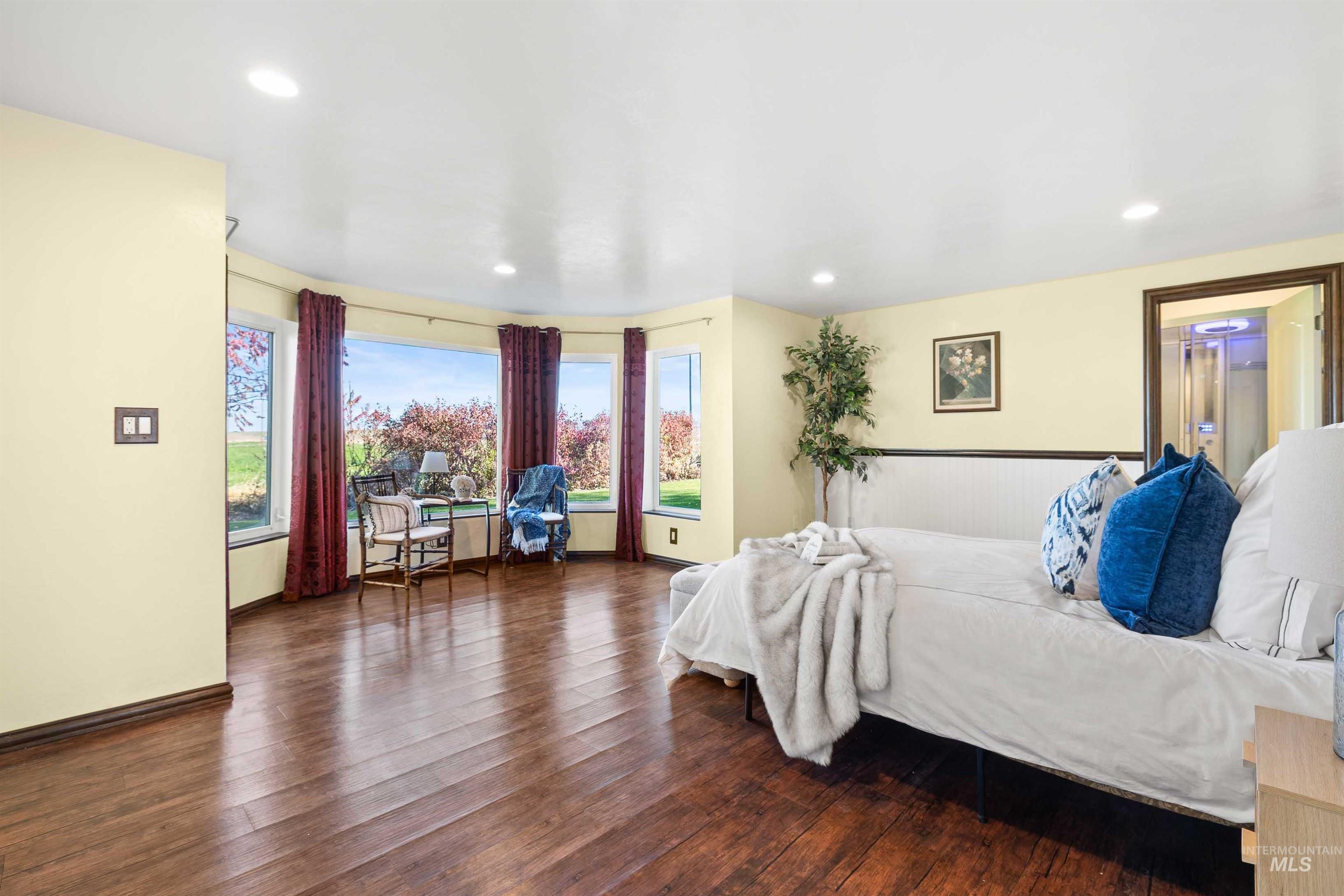 Bedroom featuring multiple windows, dark wood-style floors, and recessed lighting