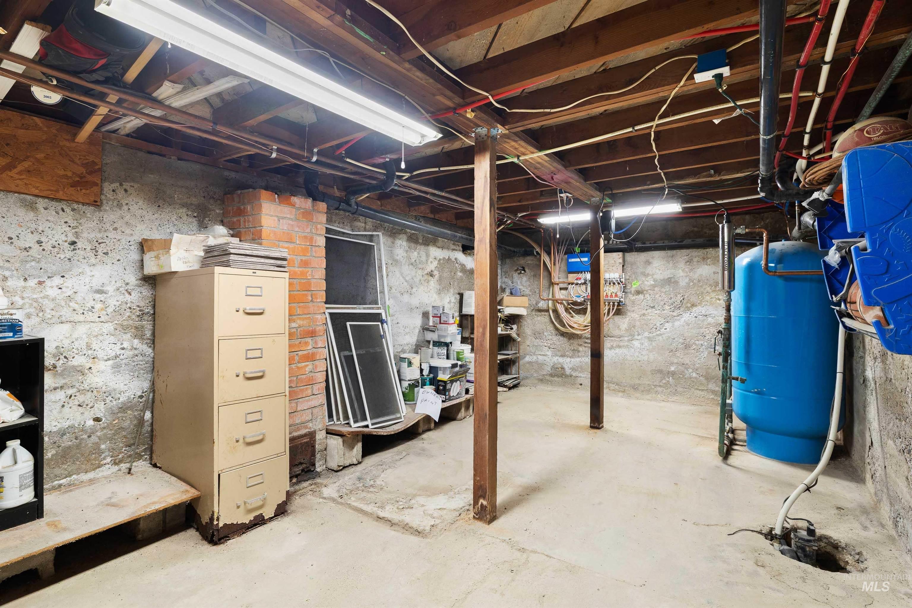 Unfinished basement featuring a water pressure tank