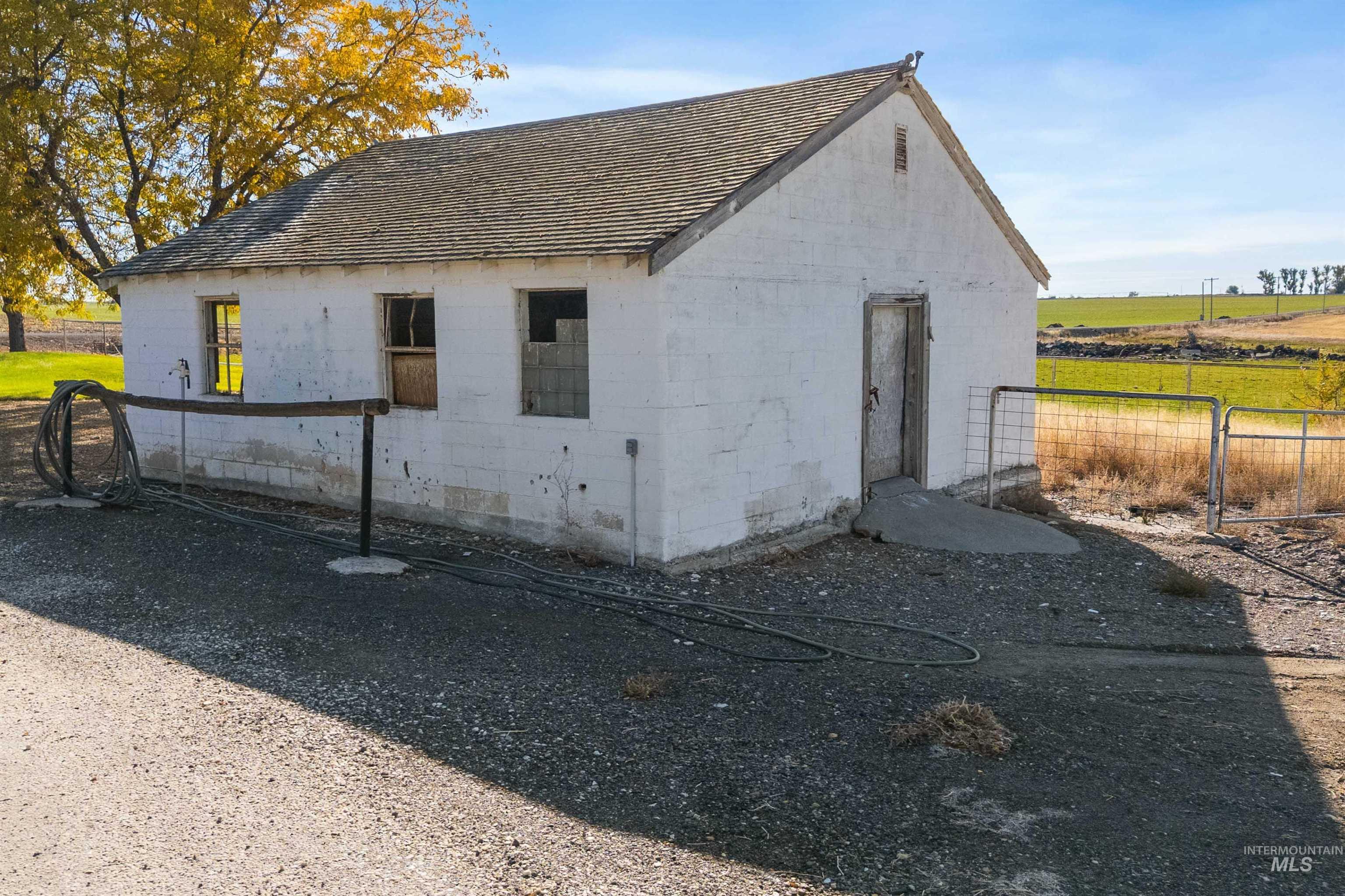 Back of property featuring concrete block siding and a shingled roof