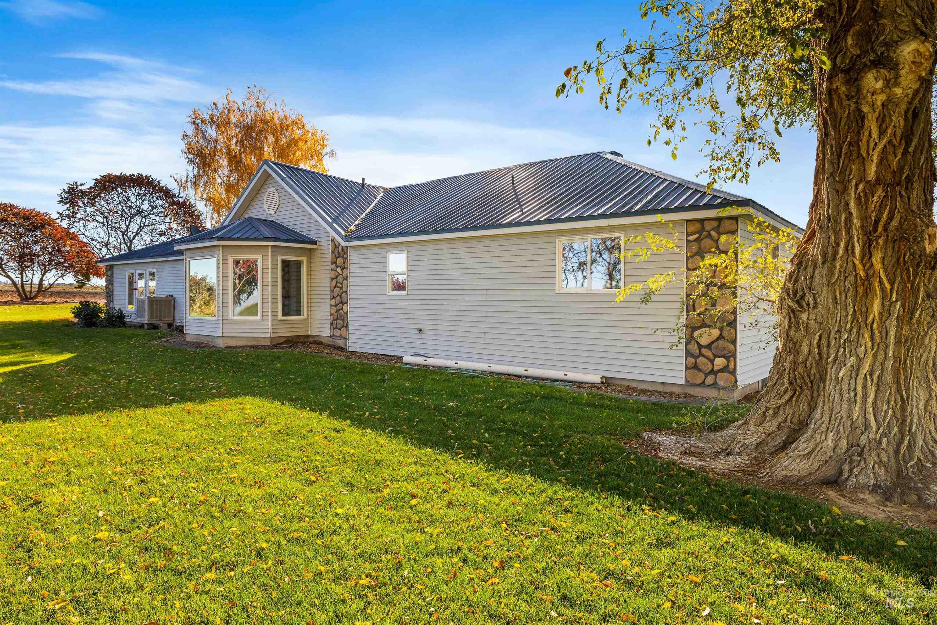 Rear view of house with a lawn and a metal roof