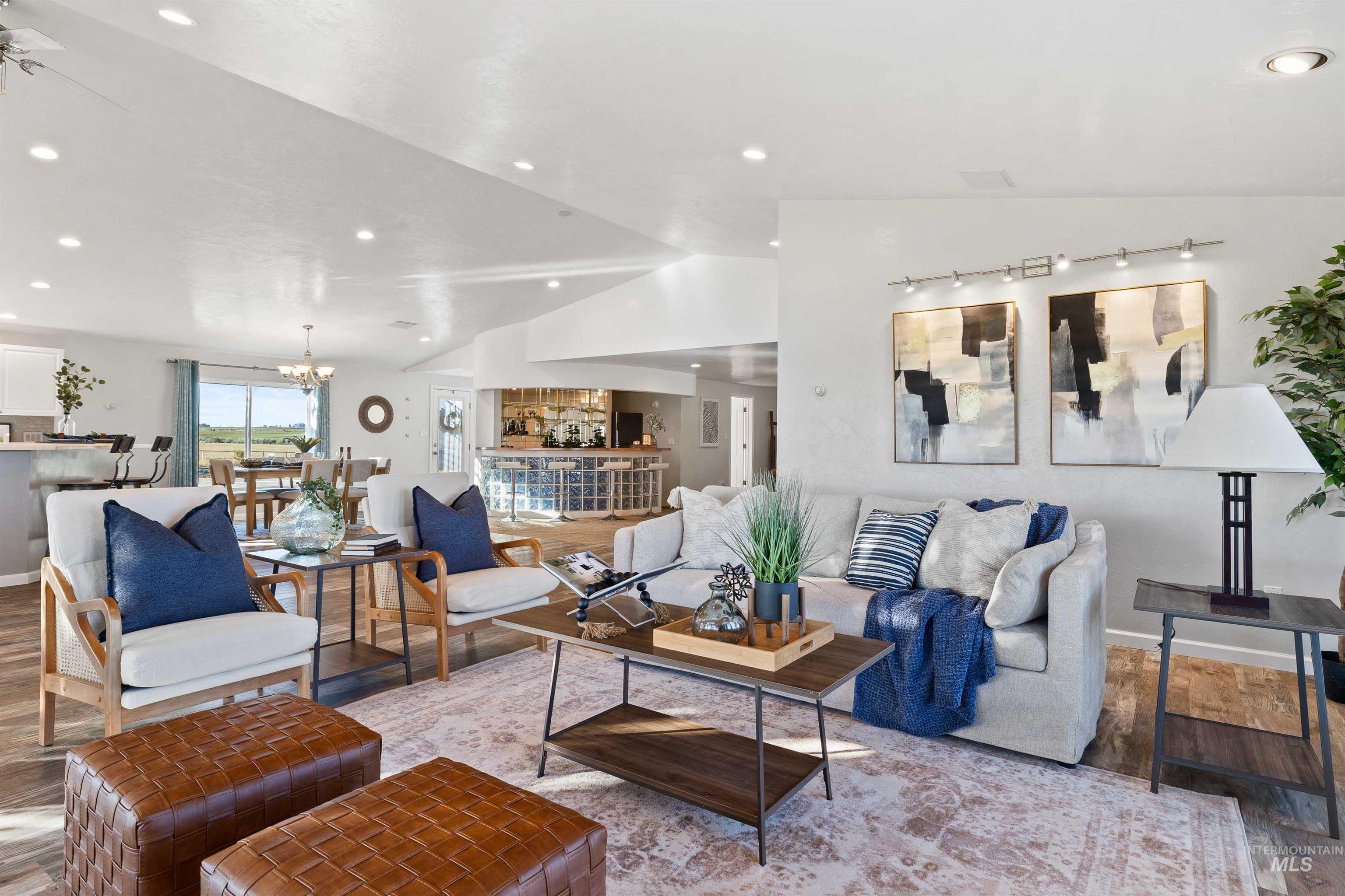 Living room featuring lofted ceiling, wood finished floors, recessed lighting, and a chandelier