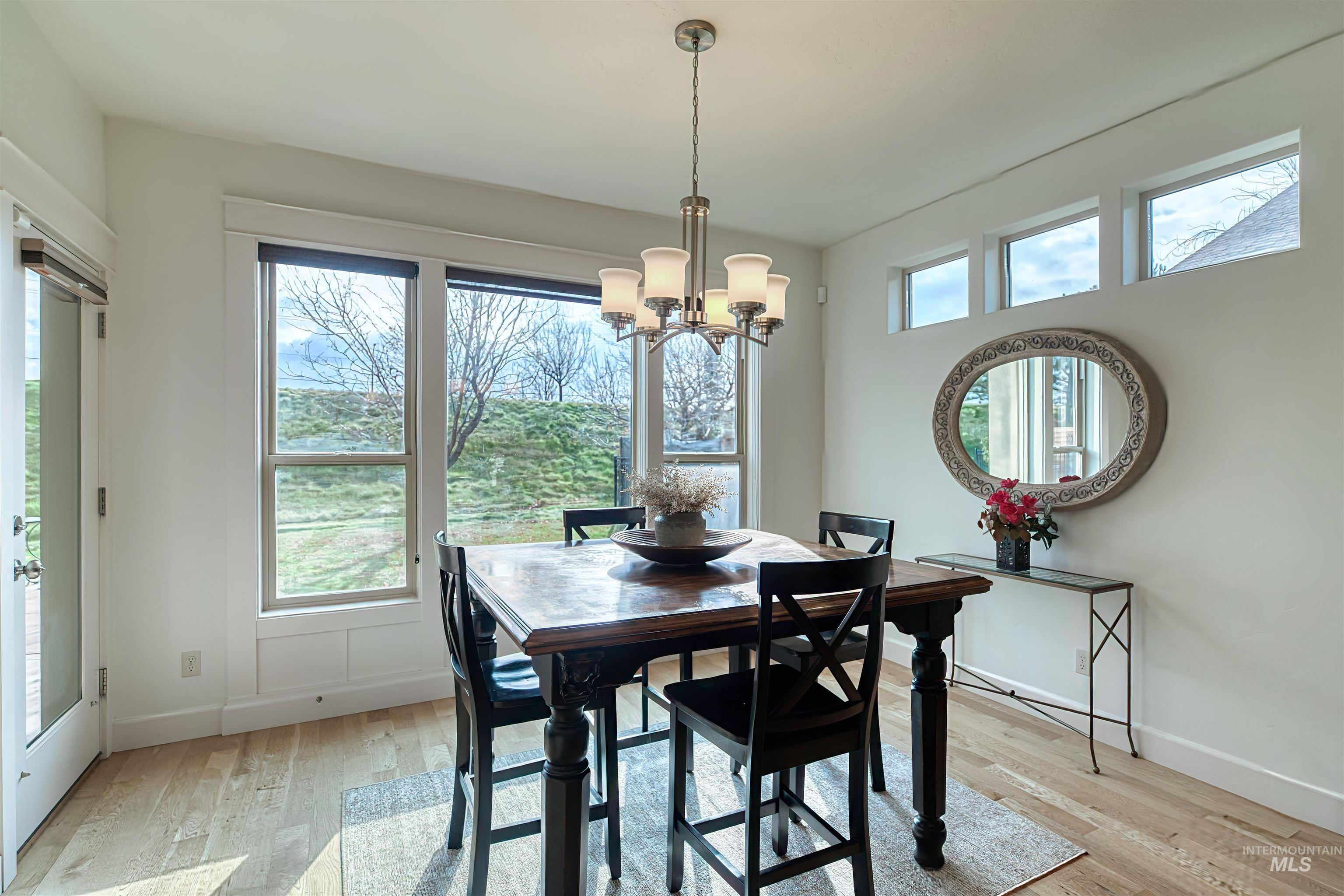 Dining area with light wood-style flooring and a chandelier