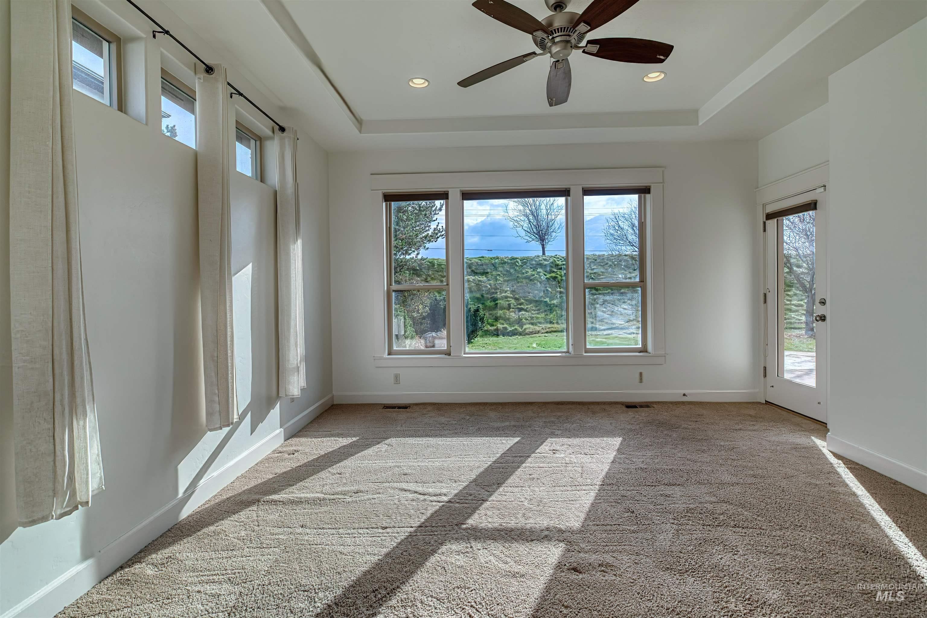 Unfurnished room with ceiling fan, light carpet, a raised ceiling, and recessed lighting