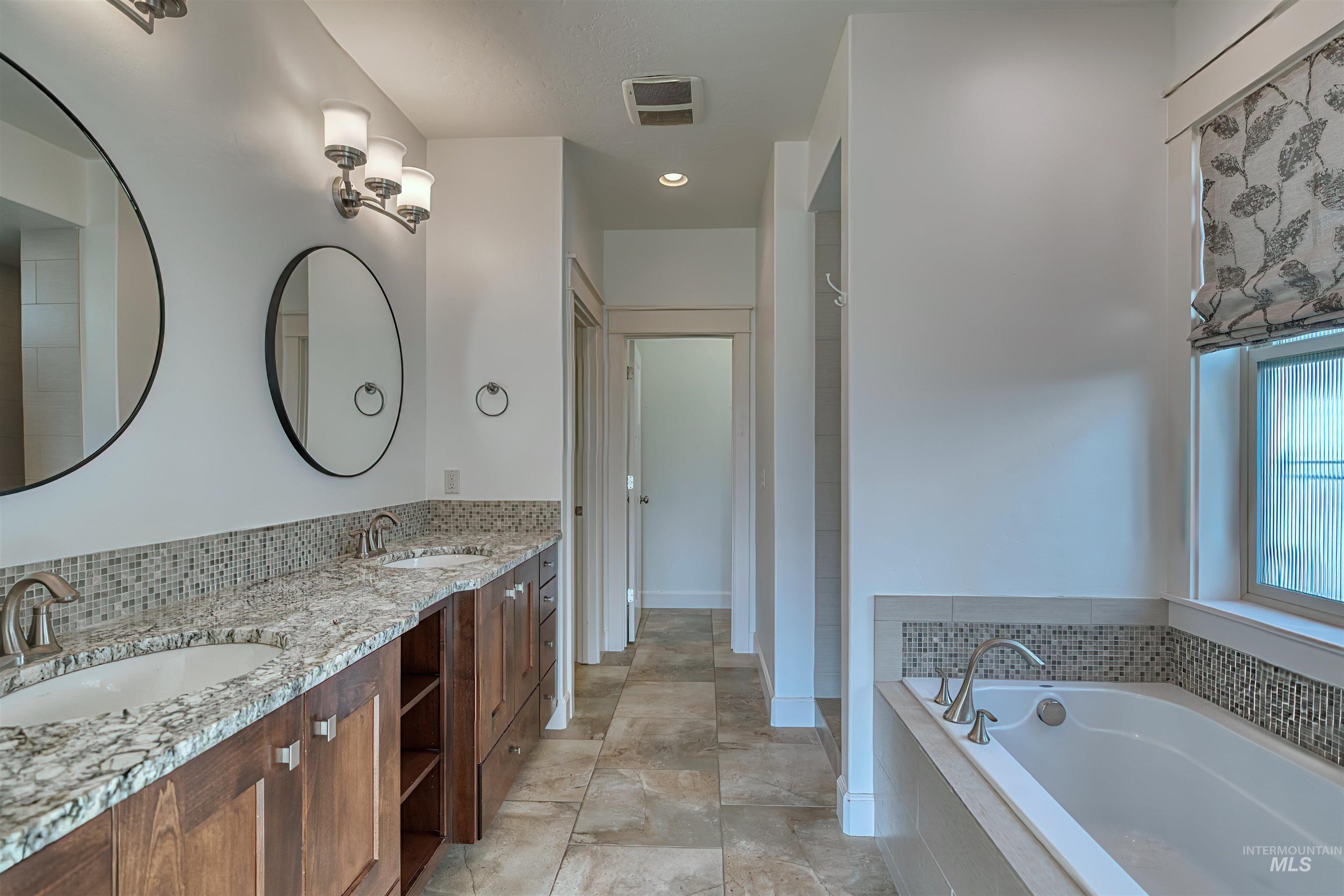 Bathroom featuring a garden tub and double vanity