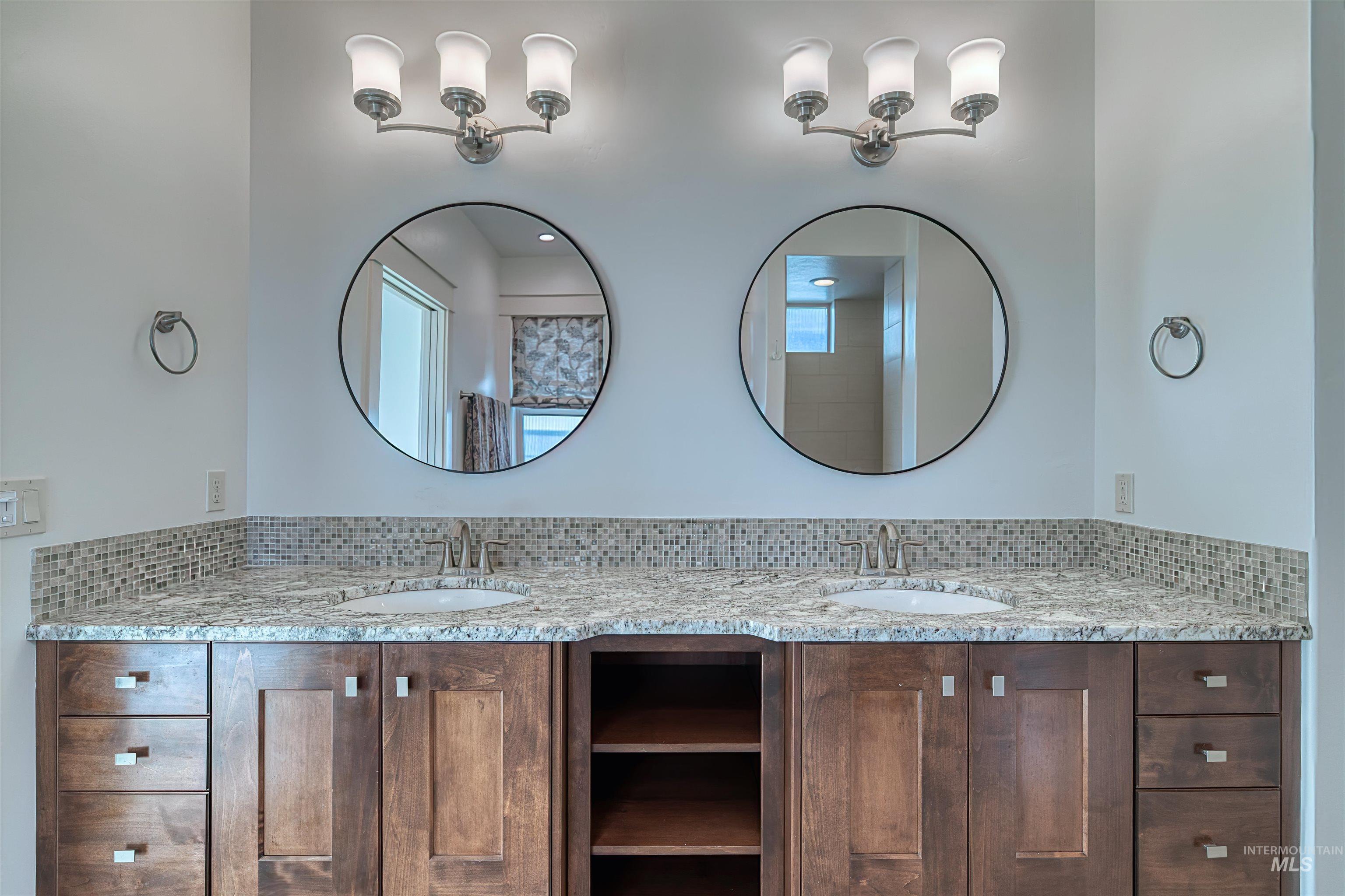 Bathroom featuring double vanity and tasteful backsplash