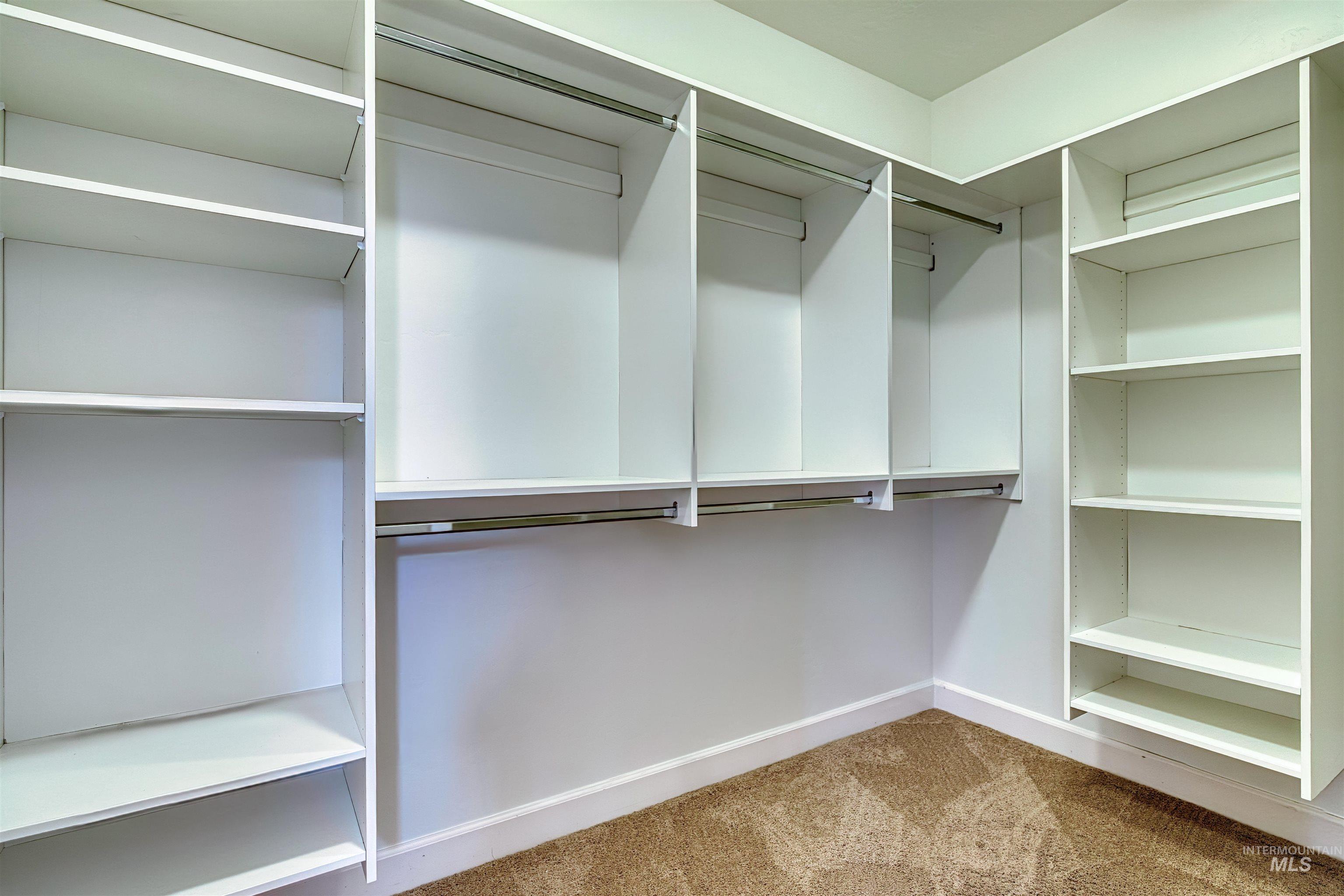 Spacious closet with light colored carpet