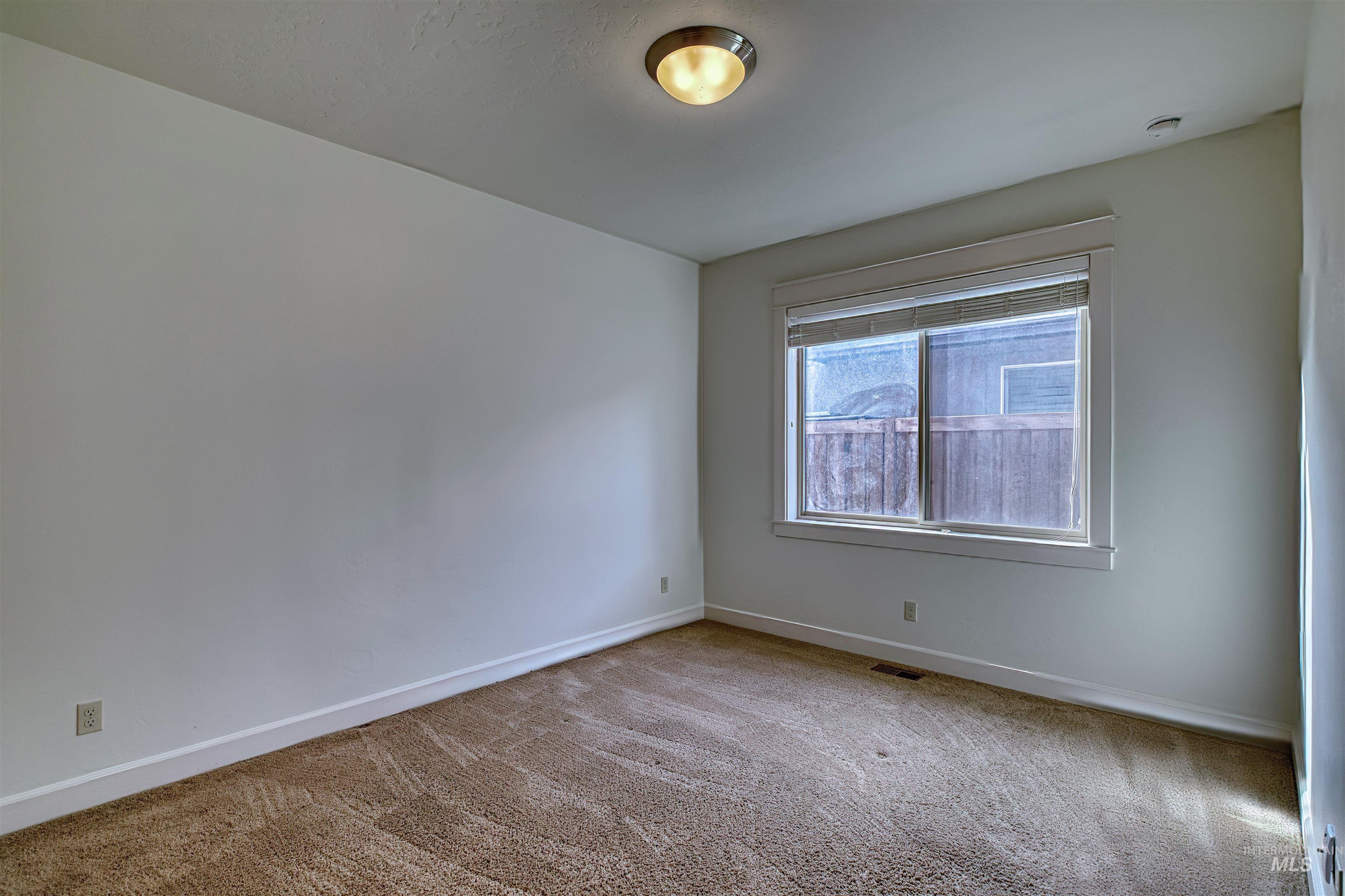 Unfurnished room with light colored carpet and baseboards