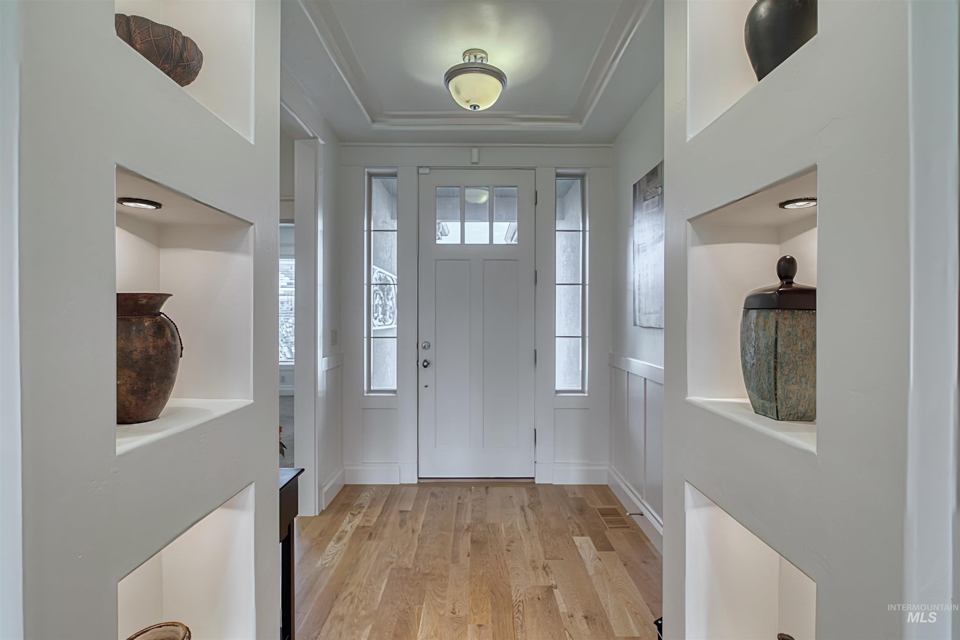 Entryway featuring light wood-style floors and a tray ceiling