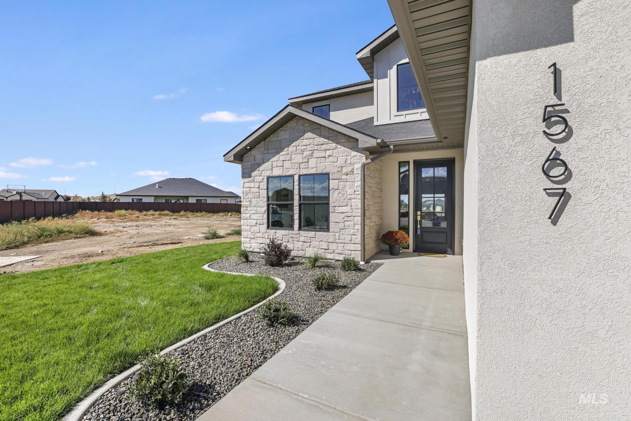 View of exterior entry featuring stone siding and stucco siding
