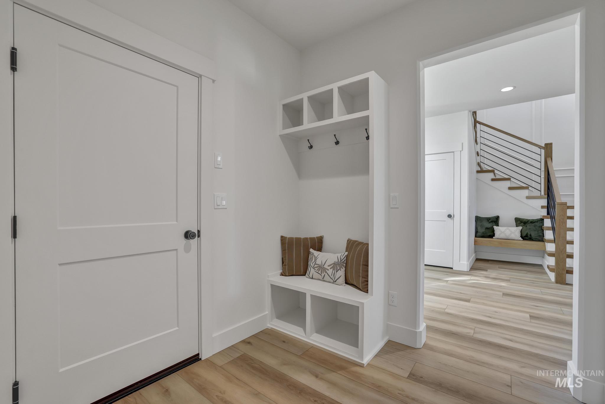 Mudroom with light wood-style flooring and baseboards