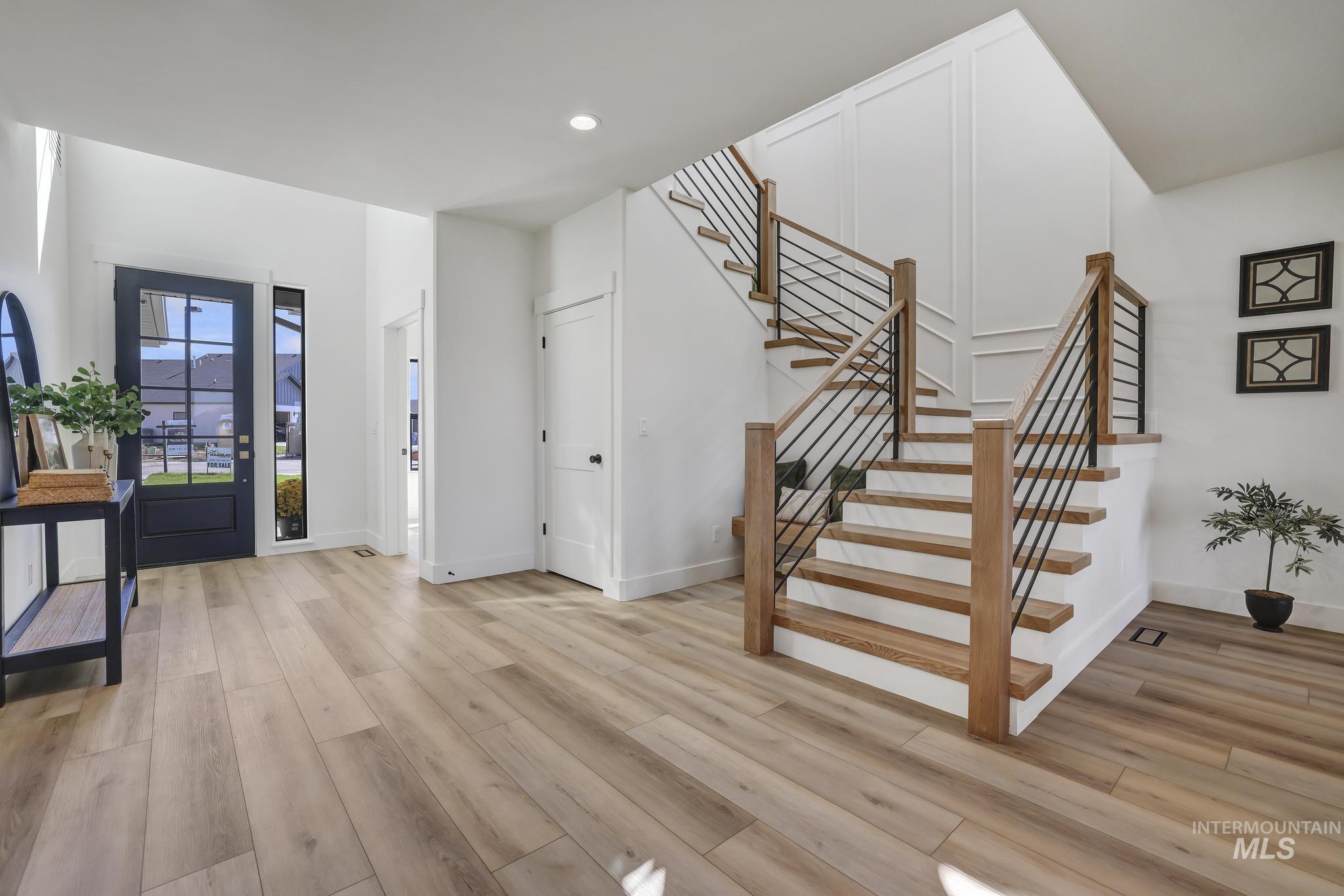 Entryway featuring light wood-style flooring, stairway, and recessed lighting