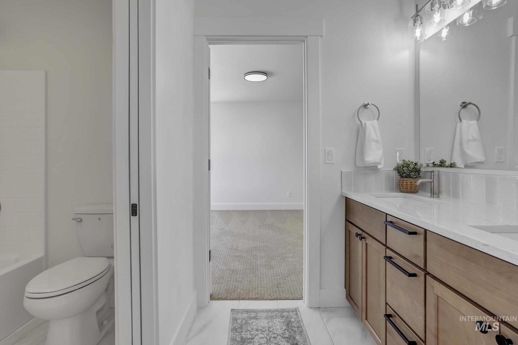 Full bathroom with double vanity, light tile patterned flooring, and shower / tub combination