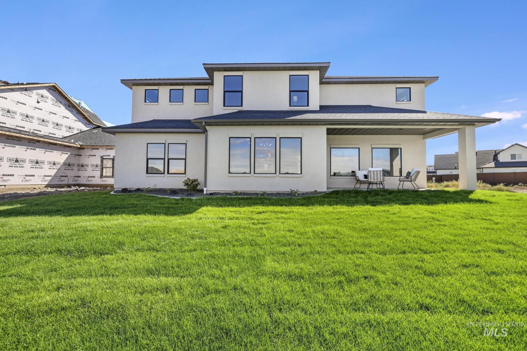 Back of property with a lawn, stucco siding, and a patio