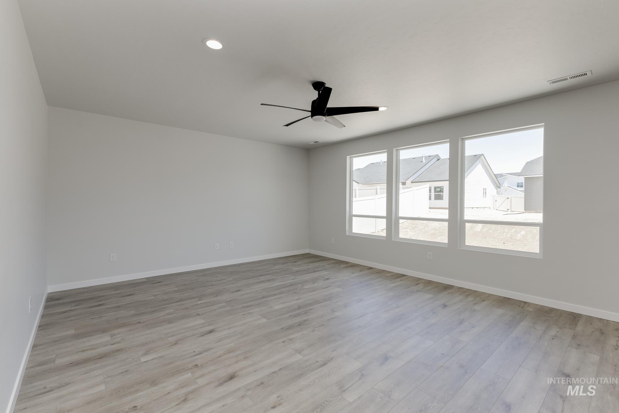 Empty room with light wood-type flooring, ceiling fan, and recessed lighting