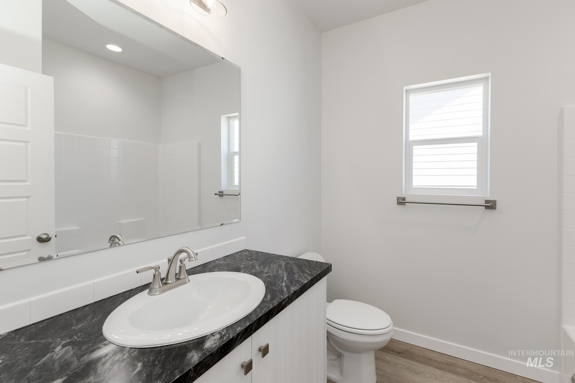 Full bathroom featuring vanity, wood finished floors, and bathtub / shower combination