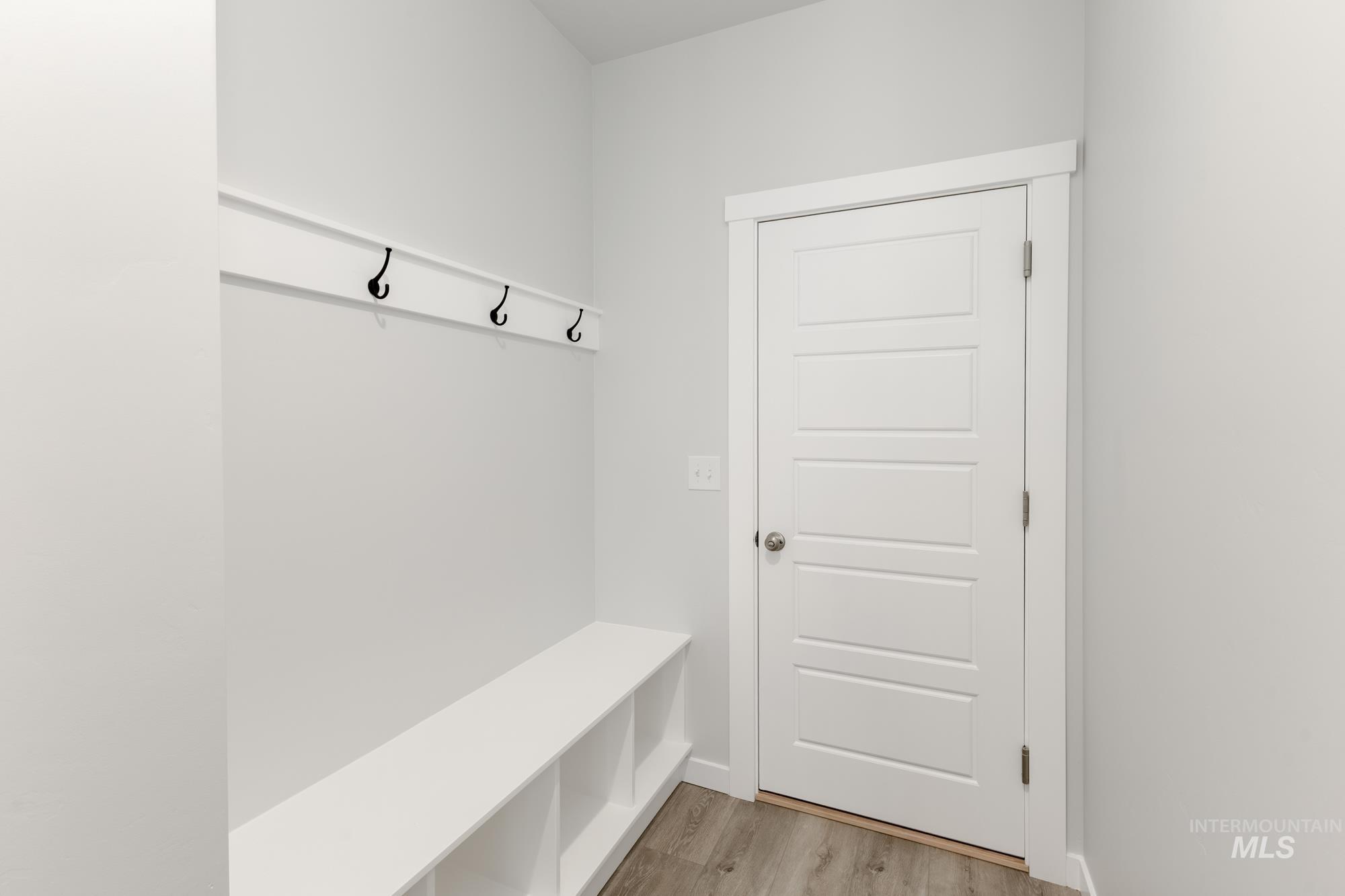 Mudroom with light wood finished floors and baseboards